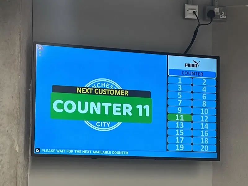 Queue management display calling Counter 11 at the Manchester City flagship Puma store